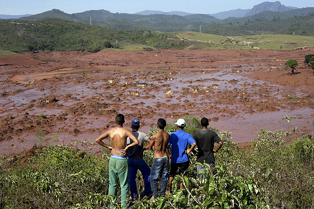 Homens observam estragos provocados pela lama no distrito de Bento Rodrigues, na cidade histrica de Mariana (MG)