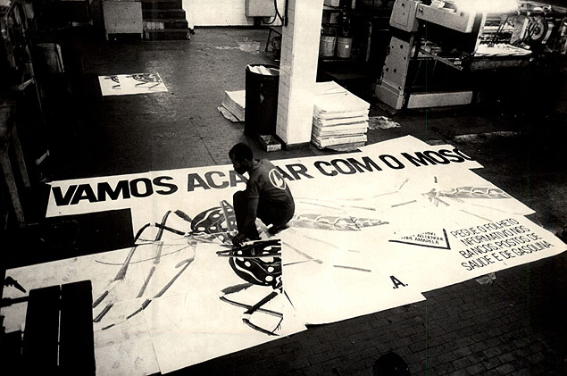 Rapaz monta cartaz da campanha contra o mosquito _Aedes aegypti_, em maio de 1986, em So Paulo