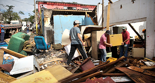 Moradores retiram os móveis que sobraram após desabamento de carro com forte temporal