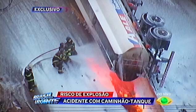 Descrio: Um caminho-pipa transportando combustvel pegou fogo aps tombar no acesso da Rodovia Ayrton Senna ao bairro dos Pimentas, em Guarulhos, na Grande So Paulo