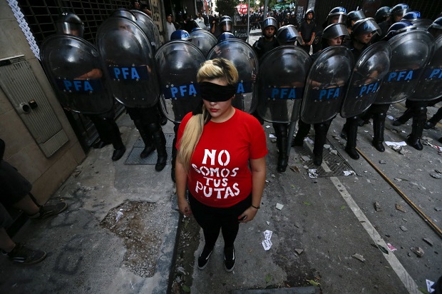 Manifestante coloca-se diante de policiais durante protesto em Buenos Aires, Argentina, contra absolvio de acusados de trfico de mulheres no caso de Marita Vern, raptada e obrigada  se prostituir