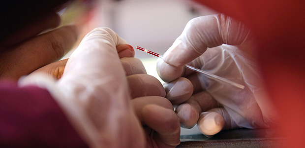 Oficial de sade recolhe amostra de sangue de um morador da provncia de Kandal, na Camboja, para realizar exame de HIV 