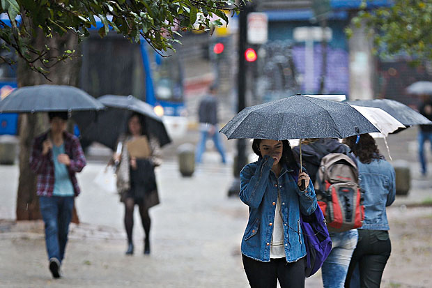 Pedestres se protegem das chuvas no vale do Anhangaba, no centro de So Paulo