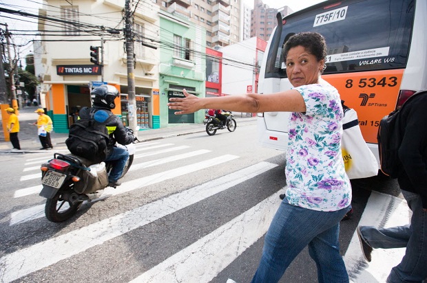 Agente da CET disfarada demonstra o "gesto da mozinha" em rua de Pinheiros, em 2012