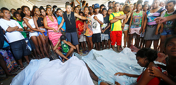 Residents react near bodies of whom police say are drug traffickers, during a police operation in the Cidade de Deus favela, in Rio de Janeiro