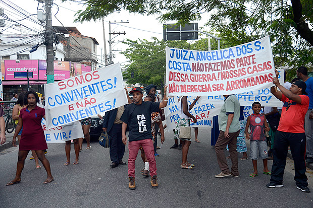 Os manifestantes seguiram por uma das principais avenidas do bairro, segurando faixas e cartazes contra a medida judicial e a represso policial a moradore
