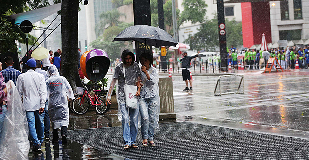 Paulistanos usam capa para se proteger durante a chuva intensa na tarde desse domingo (11), na avenida Paulista 