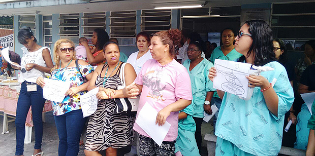 Servidores de hospitais de Minas Gerais, em greve, exibem cartazes com um desenho de um helicptero 
