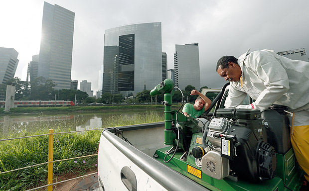 Agentes tentam consertam equipamento durante pulverizao de larvicida no rio Pinheiros
