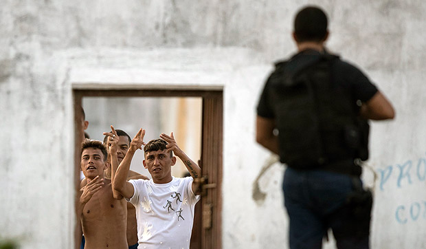 Presos fazem gestos a policiais que entram na penitenciria de Alcauz, na regio metropolitana de Natal