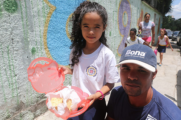 O motorista Tiago Xavier, 31, e a filha Vitria Alves de Amorim, 8, mostram lancheira que a menina levou para escola