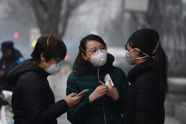 Jovens usam mscaras por conta da poluio em Pequim, na vspera do Ano-Novo