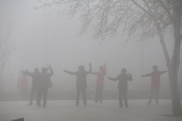 Pessoas fazem exerccio em meio a nuvem de poluio em Zhengzhou, na China