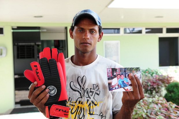 Rodrigo de Souza, irmo do goleiro Bruno, mostra um par de luvas que ganhou do jogador