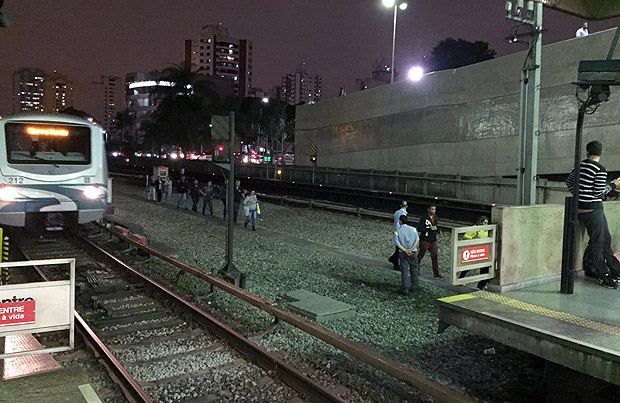 Usurios caminham nos trilhos aps falha na linha 3-vermelha do metr de So Paulo