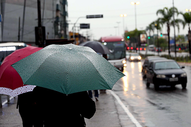 Pedestres se protegem da chuva na regio da estao Conceio, na zona sul de So Paulo