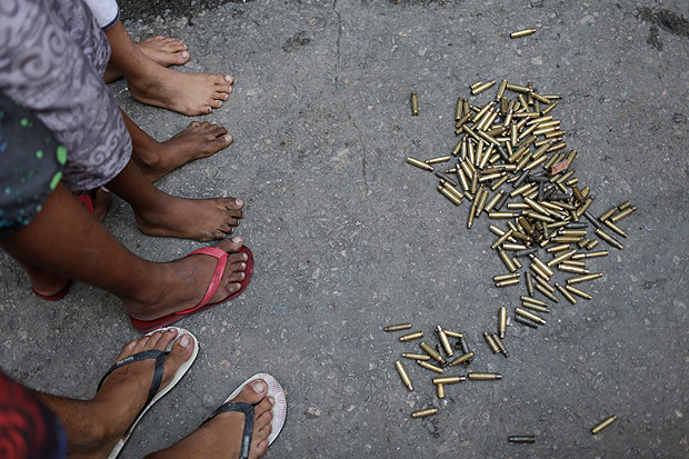 Children stand next to spent bullet casings after a police operation at the Mangueira favela in Rio de Janeiro, Brazil, Friday, June 30, 2017. A 76-year-old woman and her daughter, who tried to come to her aid, have been killed in a shootout between police and drug traffickers in the Rio de Janeiro slum. (AP Photo/Silvia Izquierdo) ORG XMIT: XSI108