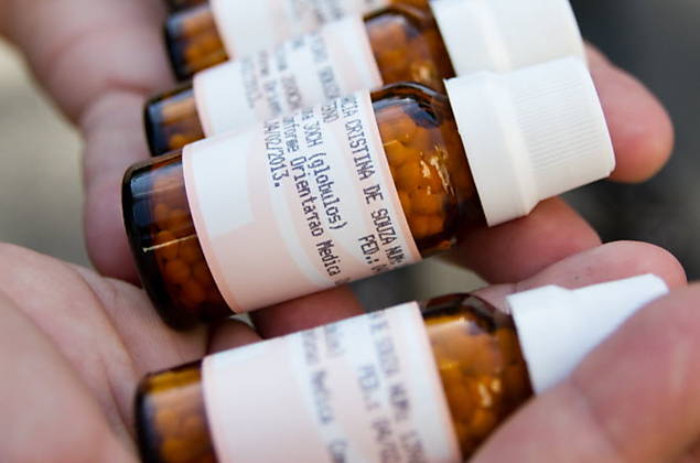Manifestante contra uso de homeopatia mostra frascos de remédio; tratamento alternativo cresce em SP