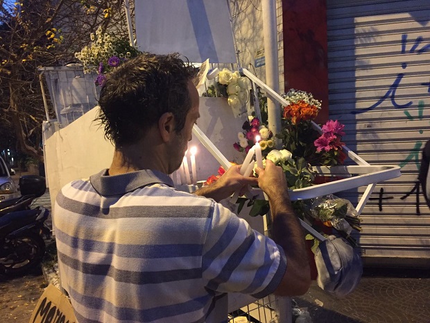 Colega de carroceiro morto pela PM acende velas no carrinho do homem, que foi pintado de branco