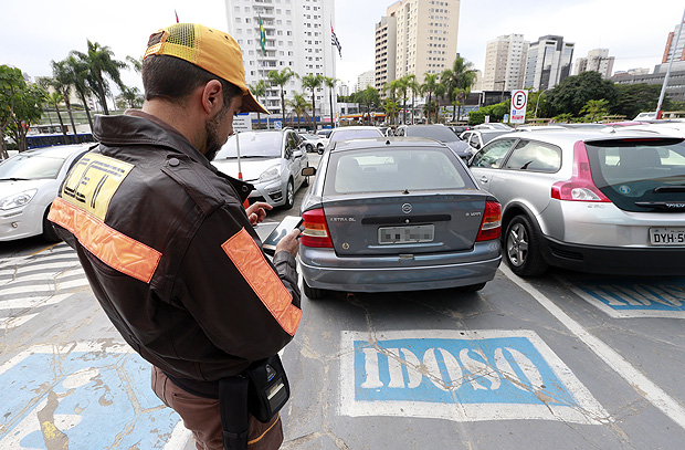 Agente da CET multa veículo em vaga de idoso do estacionamento do Shopping Ibirapuera, zona sul