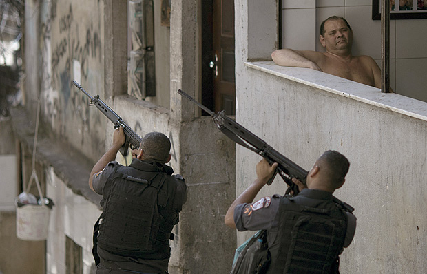 Police officers aim their weapons during an operation against alleged drug traffickers in the Rocinha slum of Rio de Janeiro, Brazil 