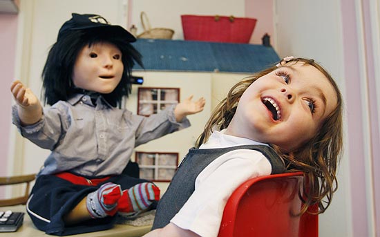 Eden Sawczenko, 4, que tem autismo, reage ao robô Kaspar, em escola ao norte de Londres