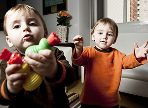 Leonardo e Rafael (de laranja), ambos de 1 ano e 8 meses, disputam brinquedos no apartamento onde vivem, em SP