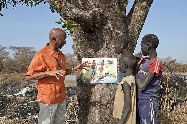 O mdico Donald Hopkins ensina trs meninos do Sudo do Sul, na frica, sobre a importncia da filtragem da gua