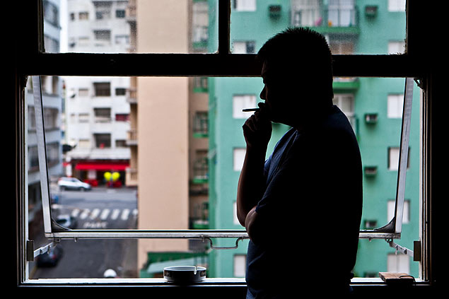 Homem que sofre com depresso fuma em seu apartamento no centro de So Paulo