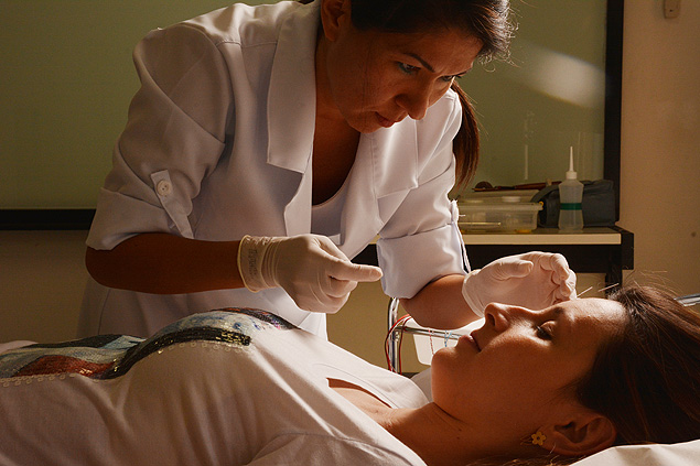 A acupunturista Valria Kim aplica agulhas no rosto de uma paciente; segundo ela, acupuntura promove o equilbrio energtico do corpo