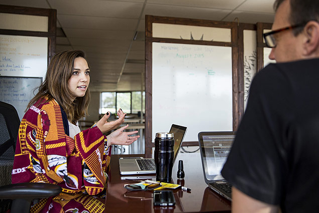 Phoebe McPherson veste um snuggie (cobertor de se vestir) enquanto conversa com um colega no escritrio