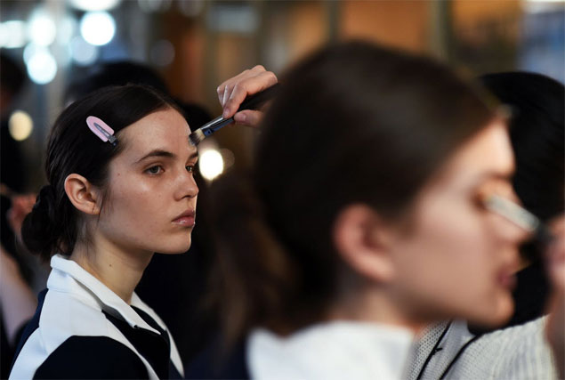 Modelos se preparam para o desfile do estilista Tory Burch, na semana da moda de NY. A presilha com um carto ou papel evita marcar os fios depois da escova 