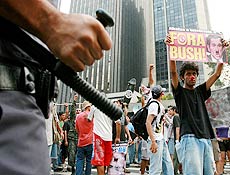 Manifestante de oposio ao presidente Bush protesta em frente a policial na av. Paulista