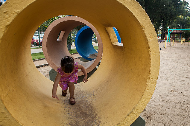 Menina brinca no parque Bosque Maia, em Guarulhos (SP)