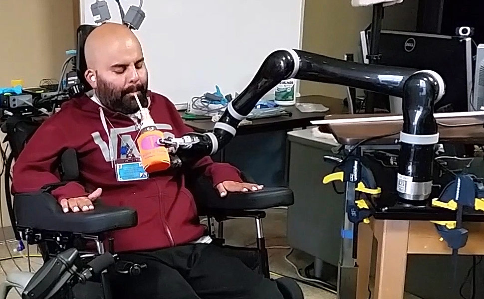 O americano Erik Sorto bebe com auxílio de braço robótico