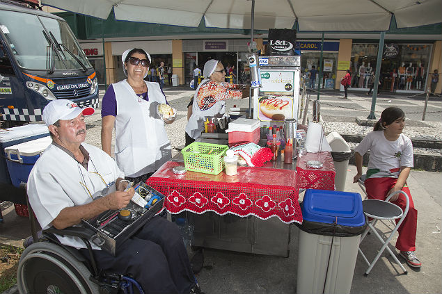 Valdir Alves, 74, cuida do carrinho com a mulher, Luclia,  direita 