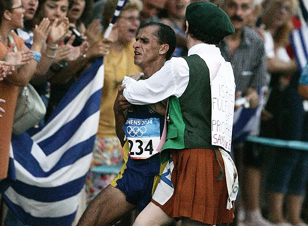 O ex-padre irlandês Cornelius Horan agarra o maratonista brasileiro Vanderlei Cordeiro de Lima, que liderava a maratona, e o derruba; Vanderlei chegou em terceiro