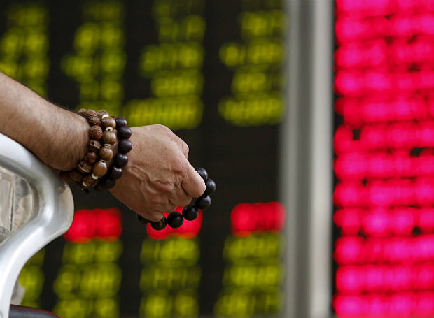 Investidor observa painel de corretora em Pequim, capital da China