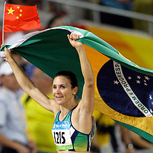 Maurren Maggi carrega bandeiras do Brasil e da China aps vencer a final do salto em distncia