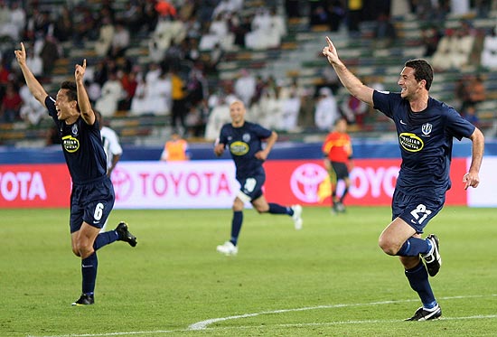 Texto: Riki Van Steeden, right, of Auckland City celebrates after scored the winner goal against TP Mazembe Aime Bakula during their Club World Cup soccer match for the fifth place in Abu Dhabi, United Arab Emirates, Wednesday, Dec. 16, 2009. Auckland City won 3-2. (AP Photo/Hassan Ammar)