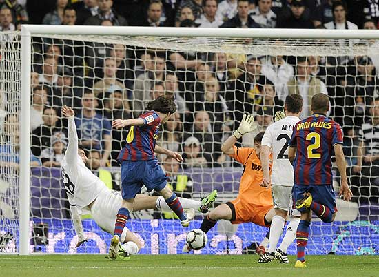 Lionel Messi chuta para fazer seu gol no clássico contra o arquirrival Real Madrid, neste sábado, pelo Espanhol