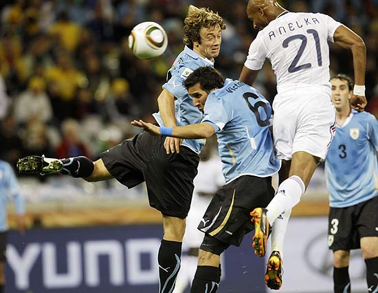 Lugano (esq.) e Victorino, do Uruguai, disputam jogada pelo alto com o francês Anelka
