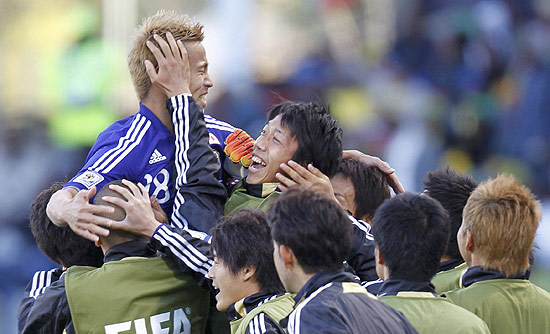 Japan's Keisuke Honda celebrates with team mates after scoring a goal against Cameroon during their 2010 World Cup Group E soccer match at Free State stadium in Bloemfontein June 14, 2010. REUTERS/Jorge Silva (SOUTH AFRICA - Tags: SPORT SOCCER WORLD CUP) 
