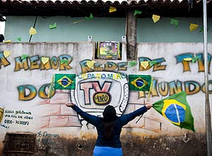 Espectadora acompanha jogo da seleo brasileira pela TV Muro, em Sabar
