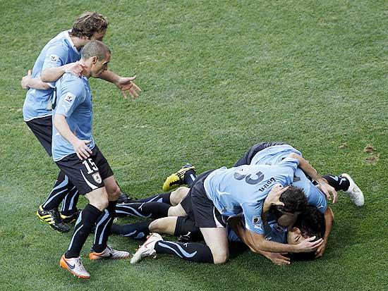 Uruguay's Luis Suarez (bottom R) celebrates with team mates after scoring a goal during a 2010 World Cup second round match against South Korea in Port Elizabeth June 26, 2010. REUTERS/Mike Hutchings (SOUTH AFRICA - Tags: SPORT SOCCER WORLD CUP) 