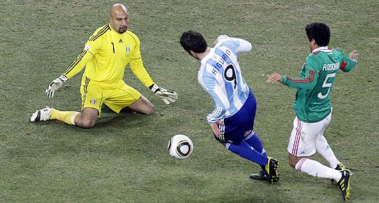 Ricardo Osorio (5) tenta tirar a bola de Higuain após perder a jogada que resultou no segundo gol argentino nas oitavas de final