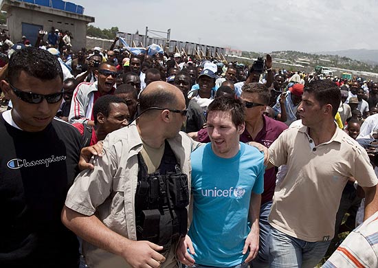 Argentine soccer star and UNICEF's Goodwill Ambassador Lionel Messi, second right, walks escorted by bodyguards during a visit to an earthquake refugee camp in Port-au-Prince, Thursday, July 15, 2010. (AP Photo/Ramon Espinosa