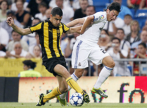 Real Madrid's Mesut Ozil of Germany (R) and Penarol's Gerardo Alcoba fight for the ball during their Trofeo Bernabeu friendly soccer match at Santiago Bernabeu stadium in Madrid August 24, 2010. REUTERS/Sergio Perez (SPAIN - Tags: SPORT SOCCER)
