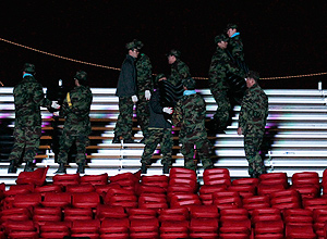 Soldados sul-coreanos trabalham durante a noite para terminar obra na arquibancada do circuito