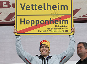 Vettel levanta a placa com a mudana, de brincadeira do nome de sua cidade natal, na Alemanha